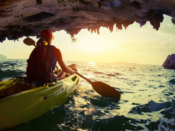 Woman canoeing towards the sunset.